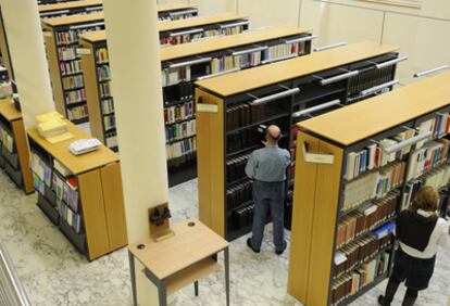 Dos personas consultan los fondos de la Biblioteca del Parlamento vasco.