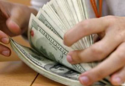 Lejos de frenar su tendencia alcista, el dólar "blue" volvía a batir récords hoy y se cambiaba a 11,80 pesos por unidad, un 70,6 % más que su precio oficial, situado en 6,81 pesos. EFE/Archivo