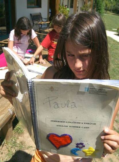 Tres niñas trabajan en el campamento del Eume con el material didáctico de la Xunta.