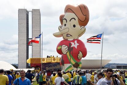 Manifestantes carregam um gigante boneco inflável da presidenta Dilma Rousseff, em protesto neste domingo em Brasília que pede o impeachment da mandatária.