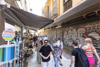 Tourists walk past the premises where the El Llavín hardware store used to be, on Tuesday.