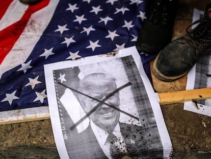 Palestinos pisan banderas estadounidenses y una foto del presidente de Ee UU, Donald Trump, durante una protesta en el norte de la Franja de Gaza (Palestina) el 7 de diciembre de 2017. 