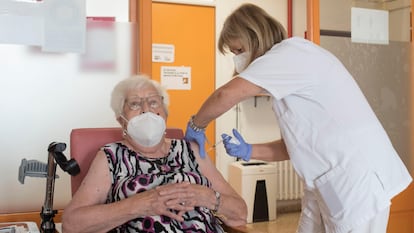 A nursing home resident receives a third shot of a Covid-19 vaccine.