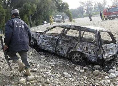 Un policía afgano camina junto a un coche destrozado tras la explosión