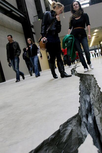 Unas jóvenes observan la gran grieta irregular que forma parte de 'Shibboleth', obra de la artista colombiana Doris Salcedo, en la galería Tate Modern de Londres, Reino Unido