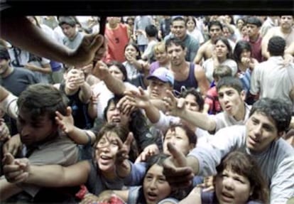 La creciente y en muchos casos nueva pobreza en Argentina detonó en forma de miles de personas que se echaron a la calle en busca de alimento. En la imagen, el dueño de un supermercado reparte comida. (REUTERS)