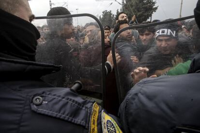 Unos 20.000 refugiados e inmigrantes han quedado atrapados en Grecia en la última semana debido a las restricciones impuestas en sus fronteras por los países de la ruta de los Balcanes hacia el norte de Europa. En la imagen, migrantes se enfrentan a la policía en el puesto fronterizo de Indomeni, en Grecia.