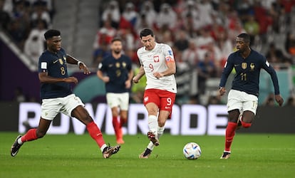 Robert Lewandowski intenta zafarse de los franceses Aurelien Tchouameni y Ousmane Dembelé.