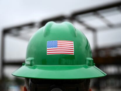 Un obrero exhibe una bandera de EE UU en su casco durante las obras de ampliación del aeropuerto de Los Ángeles