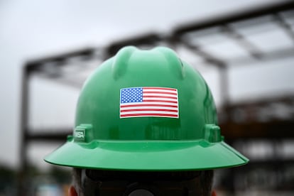 Un obrero exhibe una bandera de EE UU en su casco durante las obras de ampliación del aeropuerto de Los Ángeles