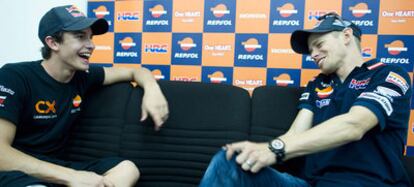 Marc Márquez y Casey Stoner conversan en el circuito del GP De Malasia.