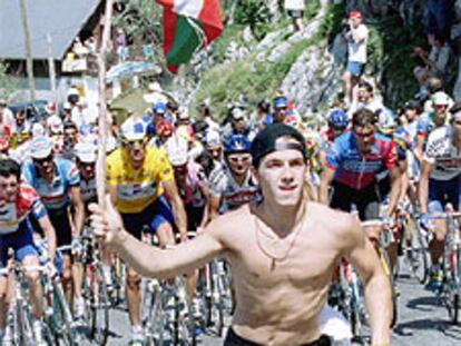 Foto de archivo de un joven corriendo delante del pelotón con una <i>ikurriña.</i>