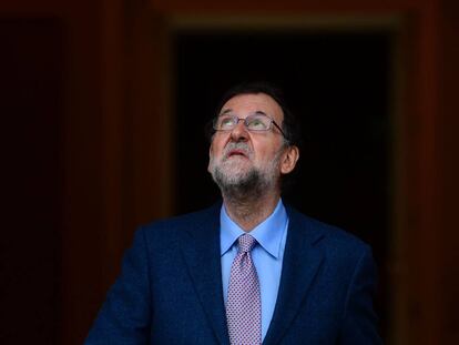Mariano Rajoy mira al cielo, antes de la llegada del presidente de Ecuador, Rafael Correa.