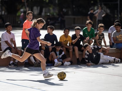 Rita, alumna de 1º de ESO del instituto Pau Claris de Barcelona, juega al futbol, animada por los chicos, durante el recreo.