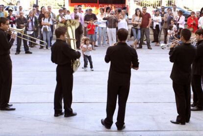 El ensemble de metales toca para un grupo de curiosos ante los Teatros del Canal.