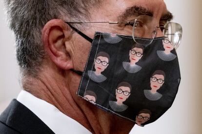 Un hombre lleva una mascarilla con una representación de la juez Ruth Bader Ginsburg durante la ceremonia privada.
