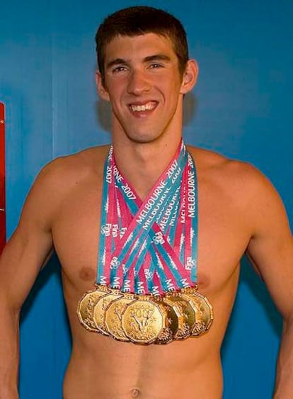 Michael Phelps exhibe con satisfacción todas sus medallas.