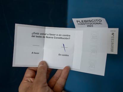 Una persona muestra su voto por la opción 'en contra' en el plebiscito del 17 de diciembre.