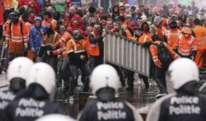 Un grupo de manifestantes se enfrenta a la policía durante en una protesta convocada por la Confederación Europea de Sindicatos (ETUC) en contra de las medidas de austeridad y recortes para afrontar la crisis económica, en Bruselas (Bélgica) hoy.