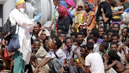 Imigrantes esperam para desembarcar no porto siciliano de Pozzallo.