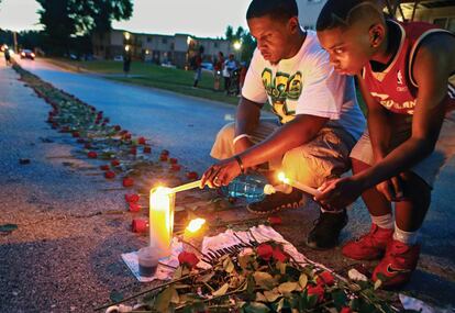 Jovens acendem velas numa rua de Ferguson, em 21 de agosto de 2014, em memória de Michael Brown, morto por um policial.