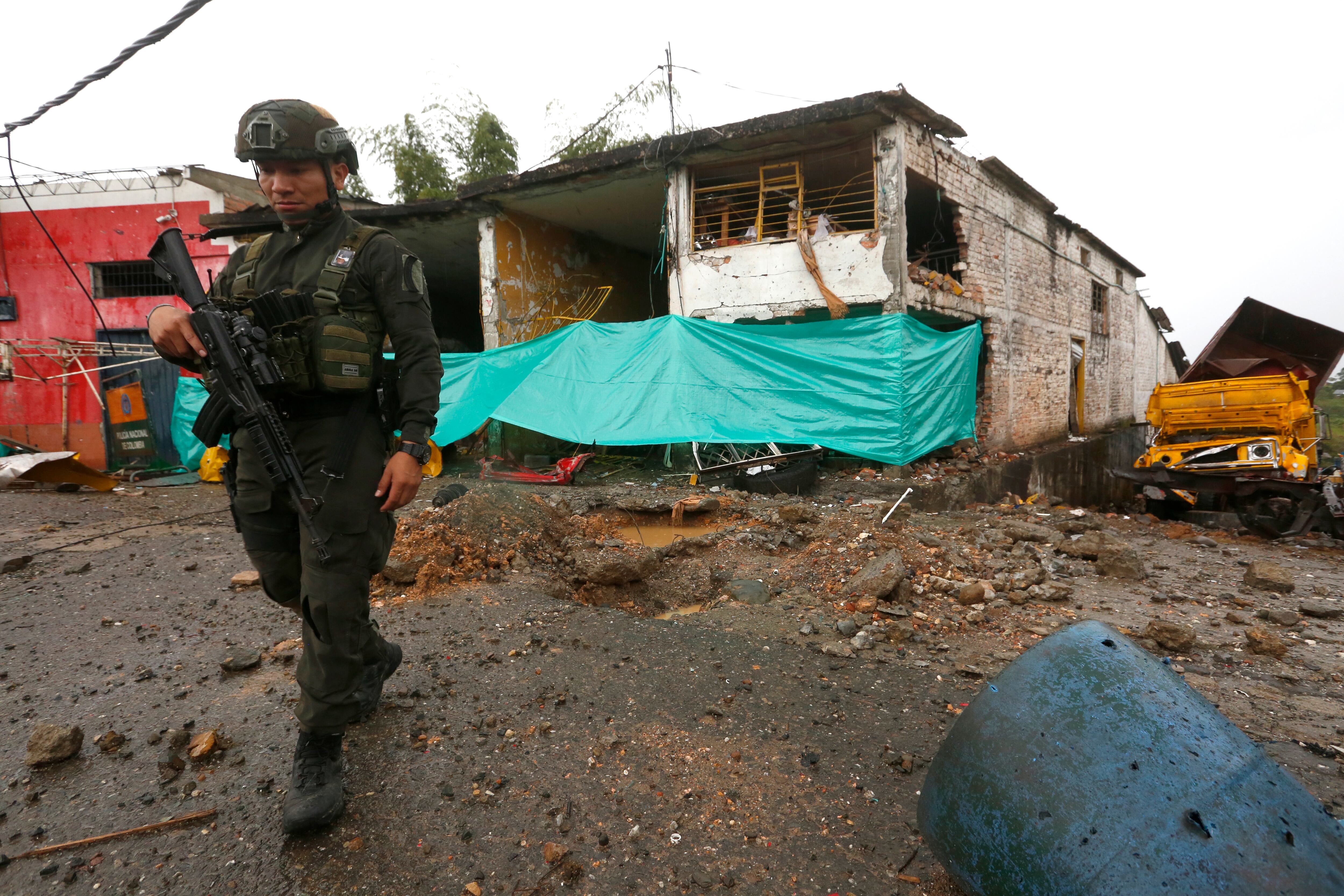 Un policía vigila junto a una casa destruida frente a la estación de policía en Morales, en el departamento de Cauca.