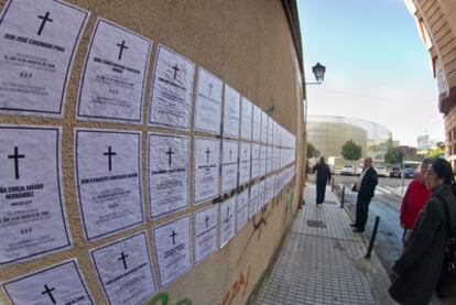 Vecinos de Badajoz miran varios carteles con los nombres de algunos de los muertos de 1936.
