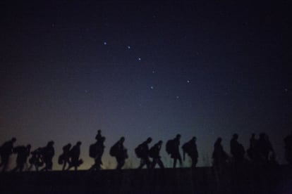 Refugiados sirios caminan por las vías del tren cerca de la frontera serbio-húngara, en Hungría en 2015.