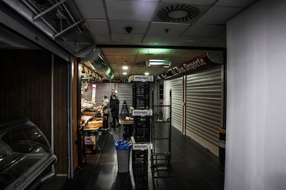 El interior del mercado de Torrijos, este lunes en Madrid, con los puestos que quedan ocupados y la parte que fue tapiada este fin de semana.