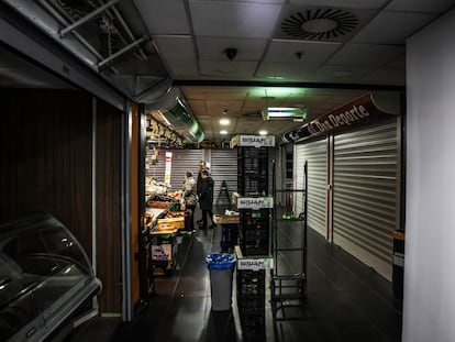 El interior del mercado de Torrijos, este lunes en Madrid, con los puestos que quedan ocupados y la parte que fue tapiada este fin de semana.