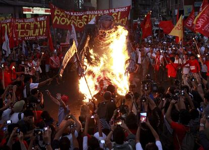 Varias personas prenden fuego a una figura que representa al presidente de la República de Filipinas, Benigno Aquino III, durante una manifestación por el Día Internacional de los Trabajadores en Manila (Filipinas).