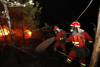 Dos bomberos trabajan en la extinción del incendio de Arbo (Pontevedra).