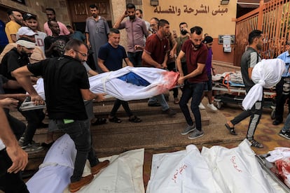 Un grupo de personas trasladan los cuerpos de palestinos asesinados durante los bombardeos de Israel, en la morgue de del hospital en Jan Yunis, al sur de la franja de Gaza, este miércoles.