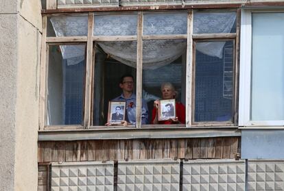 Dos personas sujetan retratos en el interior de una vivienda durante la celebración del Día de la Victoria Yevpatoriya (Crimea).