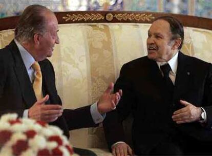 El rey Juan Carlos conversa con el presidente de Argelia, Abdelaziz Buteflika, poco después de llegar a Argel.