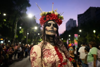 Las flores, un elemento representativo del Día de Muertos, fueron una constante en el atuendo de la mayoría de los participantes. En la imagen, una mujer con una corona de flores desfila por Paseo de la Reforma. 