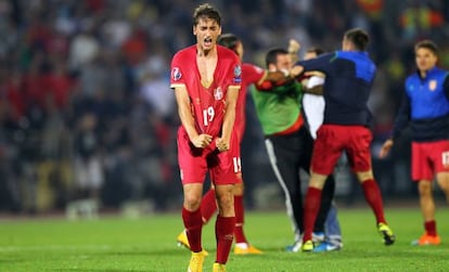 El jugador serbio Filip Djuricic se lamenta mientras, al fondo, jugadores de Serbia y Albania se pelean.  