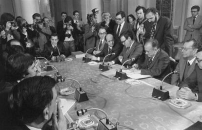 Firma de los Pactos de la Moncloa, el 25 de octubre de 1977. Presidiendo la mesa, Adolfo Suárez (presidente del Gobierno). A su izquierda, Fernando Abril Martorell (vicepresidente), Rodolfo Martín Villa (de pie), Francisco Fernández Ordóñez (ministro de Hacienda), Ramón Tamames, Alberto Aza (de pie), Santiago Carrillo (PCE), Tomás García y Jordi Solé Tura. A la izda., Felipe González (PSOE).