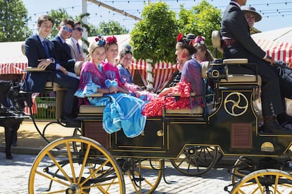 Una calesa recorre el típico paseo de caballos en el Real de la Feria.