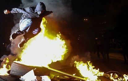 Un manifestante salta sobre una barricada en llamas en Sao Paulo, Brasil, durante una protesta contra el incremento del precio del transporte p&uacute;blico.