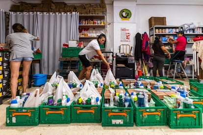 Varias mujeres organizan las cajas que repartirán a las familias con las últimas donaciones.