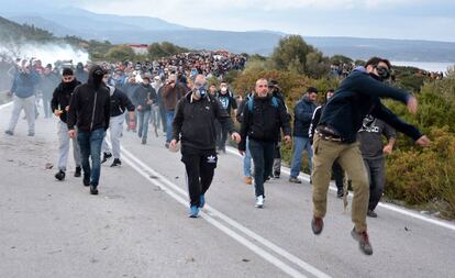 Un grupo de manifestantes lanzan piedras a los antidisturbios, este miércoles en Lesbos.