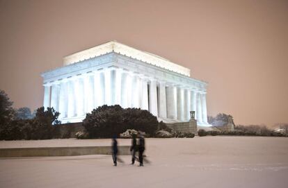 El temporal ha cubierto de nieve las calles de Washington. Un grupo de personas caminan frente al monumento a Lincoln.