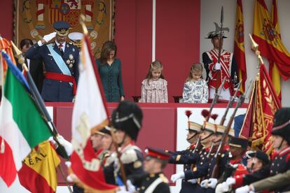 Los Reyes junto a su hijas, la princesa Leonor y la infanta Sofía, en la tribuna instalada en la plaza de Neptuno de Madrid, durante el homenaje a la bandera nacional.