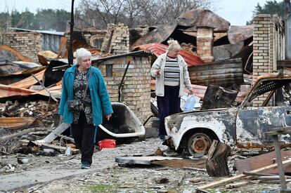 Dos mujeres caminan entre los escombros de varias viviendas destruidas durante un bombardeo en la localidad de Moshchun, cerca de Kiev. La primera quincena de abril se ha saldado en Ucrania con más de 600.000 nuevos desplazados internos, fruto de una intensificación del conflicto que eleva ya a 7,7 millones las personas que han huido de sus hogares y no han salido del país. Esta cifra implica que el 17% de la población ucrania es ahora desplazada, según la ONU. Las mujeres representan al 60% de los últimos desplazados.
