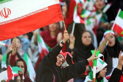 Una mujer ondea la bandera de Irán durante el partido de clasificación para la Copa Mundial de la FIFA entre Irán y Camboya en el Estadio Azadi en Teherán (Irán).