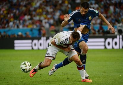 Miroslav Klose compite por el balón con el defensa Ezequiel Garay.