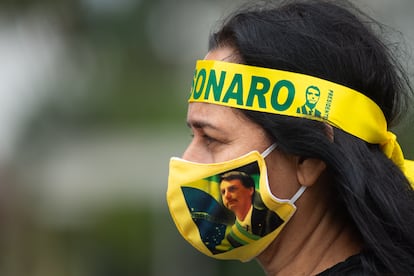 Una partidaria de Jair Bolsonaro usa un cubrebocas con el rostro del presidente brasileño, en mayo de 2020 en Brasilia.