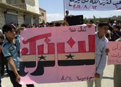 En esta imagen de periodismo ciudadano tomada con un teléfono móvil cedida por Shaam News Network, los manifestantes contra el régimen de Bachar el Asad muestran una bandera en la que se lee" "Basta de muertes. No nos doblegraremos", en una manifestación contra el régimen sirio en la ciudad de Maarat Harma, en la provincia de Edilb, al norte de Siria, ayer.