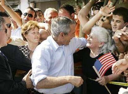 George Bush habla con una mujer durante una parada en la localidad de Fushe Kruje, cerca de Tirana.